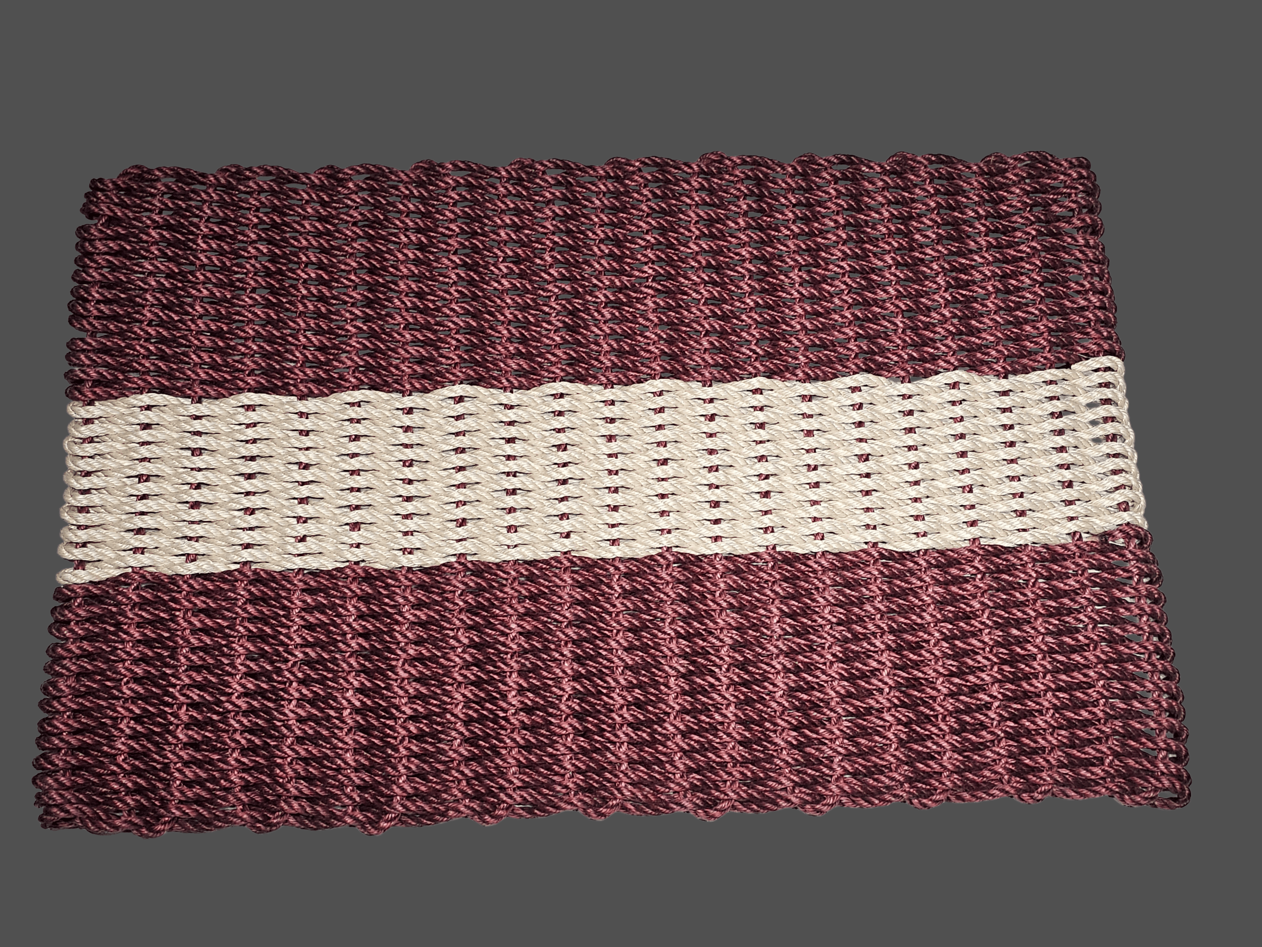Handwoven burgundy lobster rope doormat with one light tan stripe